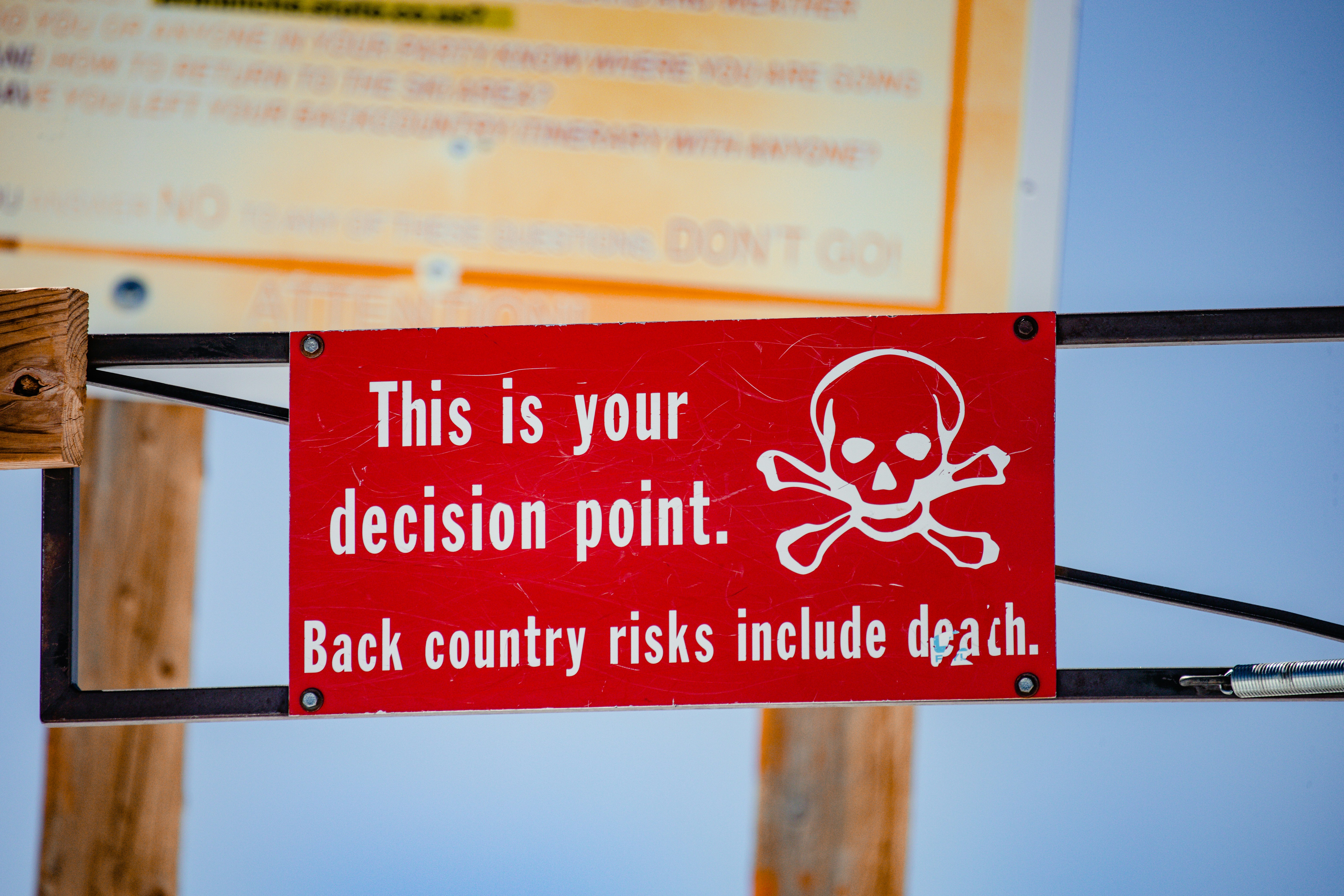 red and white signage on brown wooden post